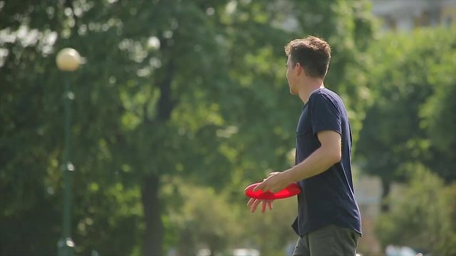 Big boy and his sweetheart are playing a flying disc game on a lawn in slow motion