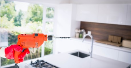 Hand holding drill machine in kitchen
