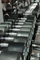 Fototapeta na wymiar Black and Steel Dumbbells in Gym: Weight Fitness Equipment