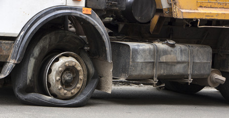 Fototapeta na wymiar Flat tire of an old fragment of a rusty broken truck