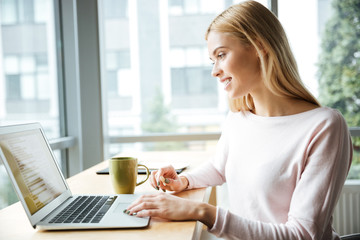 Young happy lady sitting in office coworking