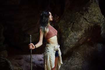 Young girl on the background of an old cave. The concept of harmony with nature .