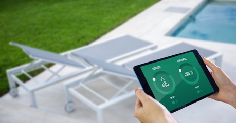 Hands using smart home application on digital tablet at poolside