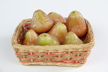wax apples in a bamboo basket isolated on white background
