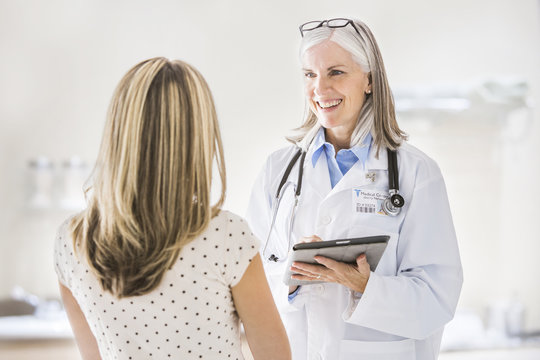 Caucasian doctor with digital tablet talking to patient