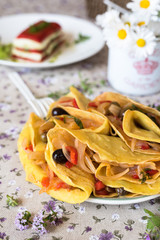 crespelle vegane ripiene di peperoni, cipolle e olive e altri cibi vegetariani per pic nic sfocati sullo sfondo