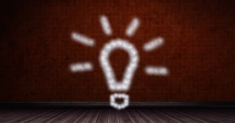 Obraz premium Digital composite image of light bulb shape on brick wall