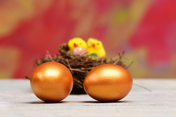 Obraz na płótnie Canvas easter golden eggs and yellow hen, chicken bird in nest