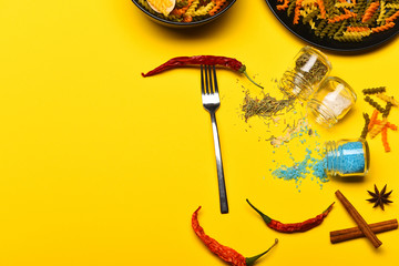 Metal fork with red chilly peppers and dried fusilli pasta