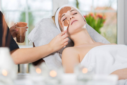 Woman getting chocolate mask treatment in spa