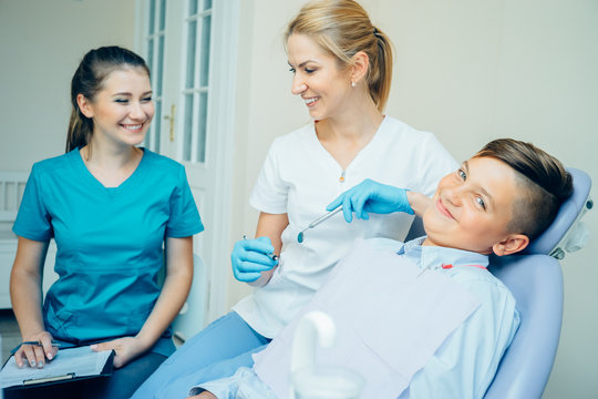 Femaleale dentist, her assistant and handsome patient in dental practice.