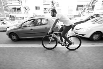 Fototapeta na wymiar Cyclist man riding fixed gear sport bike in sunny day on a city