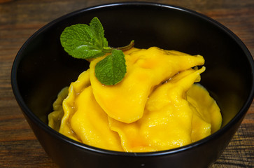 Sweet pumpkin ravioli with banana on a wooden background.