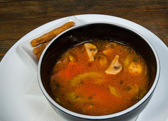Coconut milk soup with chicken and mushrooms, Thai traditional dish on a wooden background
