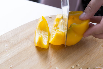 Cut vegetables on a wooden board. Red and yellow peppers, Broccoli.