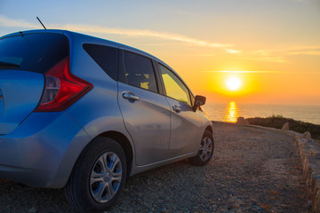 Fototapeta na wymiar a car at the sea on sunset background.