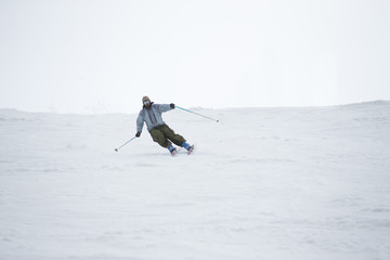 Fototapeta na wymiar Skier in mountains, prepared piste and sunny day
