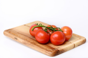 Tomatoes. cherry on vine on cutting board. Isolated on white