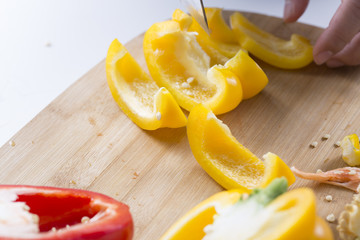 Cut vegetables on a wooden board. Red and yellow peppers, Broccoli.