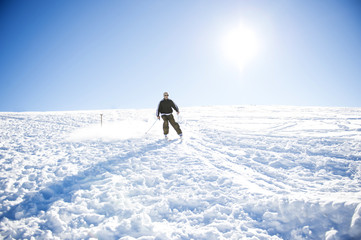 Fototapeta na wymiar Freestyle ski jumper with crossed skis in snowy mountains