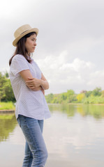 young beautiful woman relaxing in park nearby lake