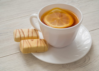 A cup of tea with lemon on a wooden table