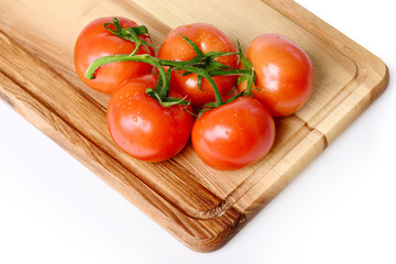Tomatoes. cherry on vine on cutting board. Isolated on white