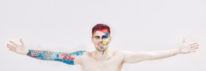 portrait of young attractive man with colored face paint on white background. Professional Makeup Fashion. ffantasy art makeup