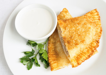 cheburec cut open with yogurt and parsley