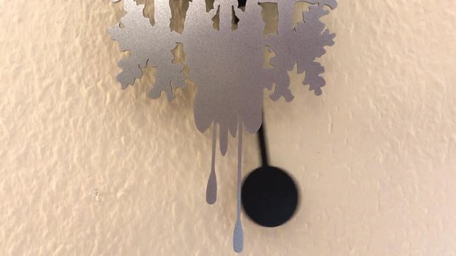 Pendel einer Uhr an der Wand bewegt sich von links nach rechts