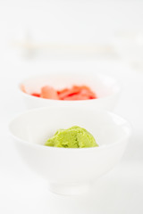 Condiment for a Japanese meal. Wasabi and pickled ginger in white bowls