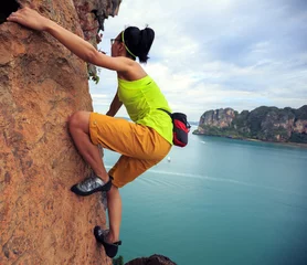 Keuken foto achterwand Alpinisme young woman rock climber climbing at seaside cliff