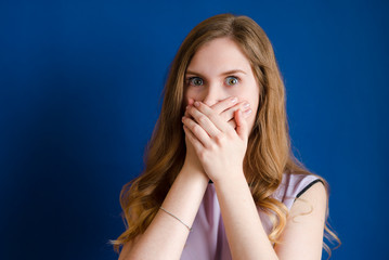 A girl holds her mouth with her hands