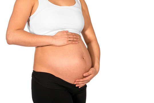 Pregnant woman embracing her bare belly with white background