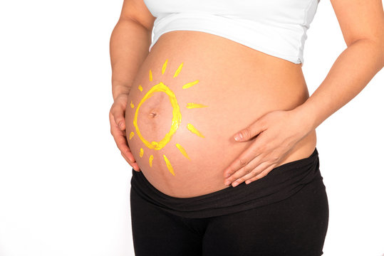Yellow sun painted on bare belly of pregnant woman