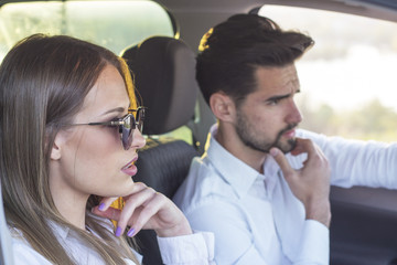 couple in car with sunset on background