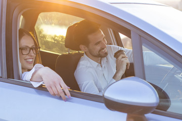 couple in car with sunset on background