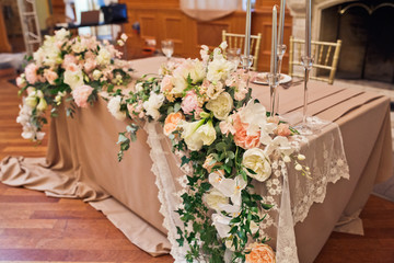 White veil hangs from dinner table prepared for newlyweds