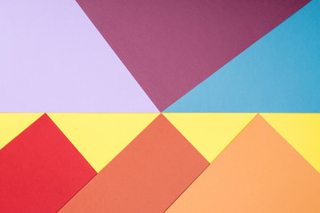 Color papers geometry flat composition background with yellow, red, orange, brown, blue tones.