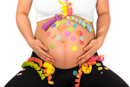 Colorful streamers and confetti on bare belly of pregnant woman