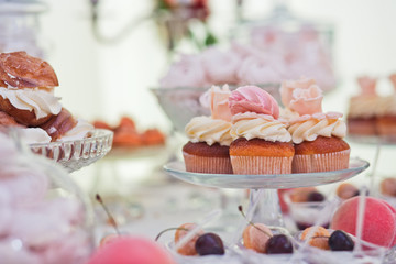 Tasty cupcakes with cream stand on the glass plate