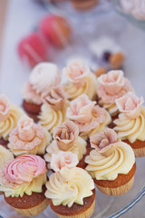 Tasty cupcakes with cream stand on the glass plate