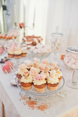 Different kinds of sweets and candies served on glass plates stand on the table
