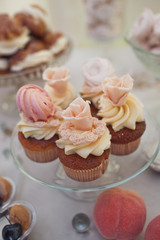 Delicious cupcakes with icing flowers and beige cream