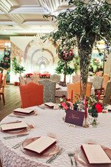 Obraz premium Bouquets of greenery stand on brown tables in the restaurant