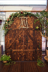 Greenery decorates wooden gates made as wedding altar