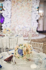 Beige bouquet stands in the middle of round table in the restaurant