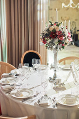 Red and white flowers put on candleholder in the middle of dinner table