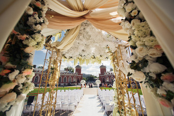 Look from below at wedding altar decorated with brown cloth and white flowers