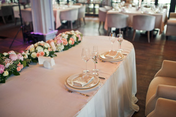 Dinner table for wedding couple served with white plates and crystal glasses